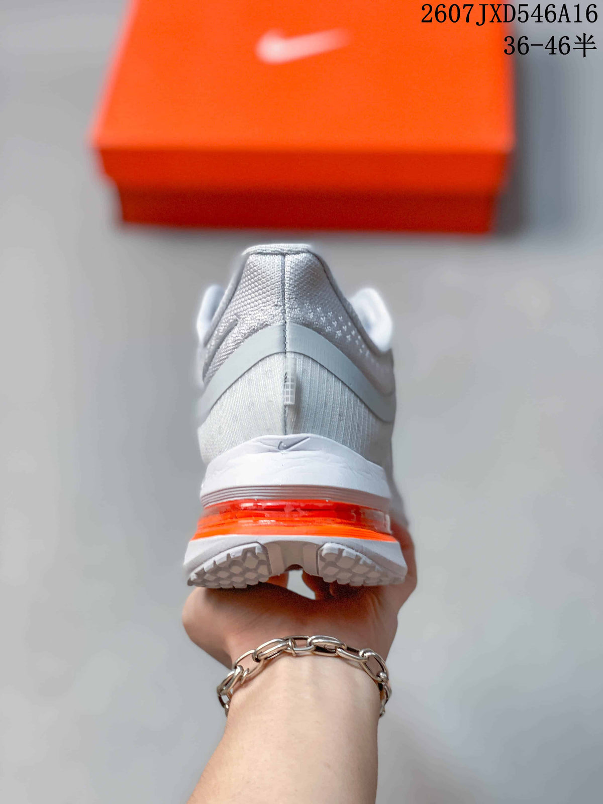 Rear view of the sneaker showing the white heel, gray upper details, orange midsole element, and textured outsole.