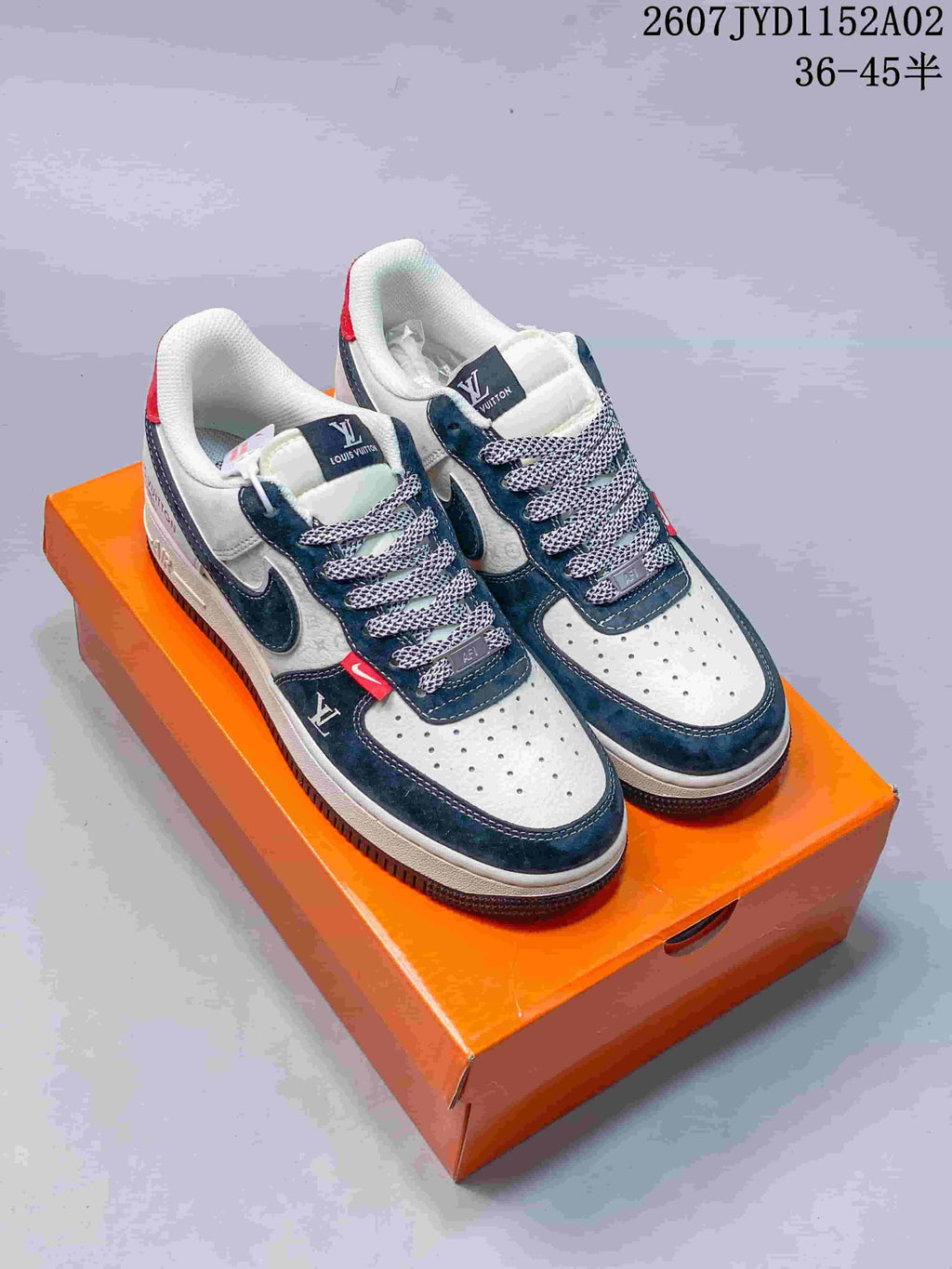 Pair of white and navy sneakers with perforated toe boxes and patterned laces