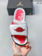 Top view of a single Jordan slide showing the white strap, red Jordan Wings graphic, and textured red footbed; image text shows style code 2607LD240A20 and sizes 40–45.
