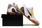 White and multicolor shoes with gum-colored outsoles displayed on a black shoebox.