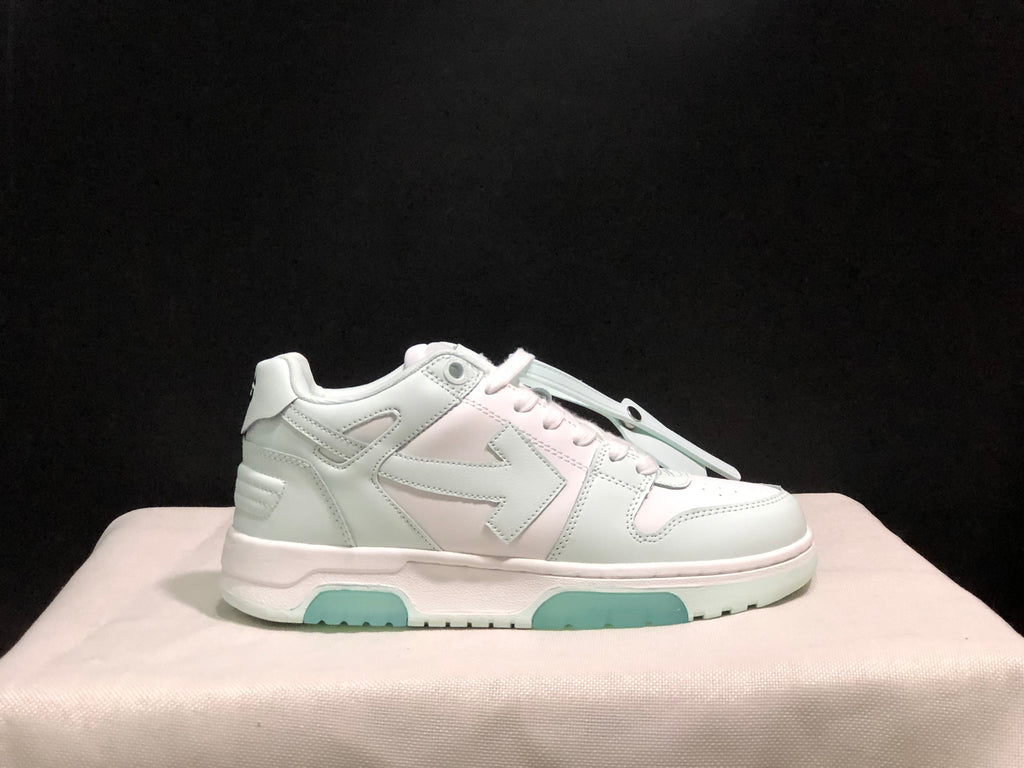 Side profile of the white sneaker showing the low-top shape, layered panels, heel detailing and pale mint outsole accents.