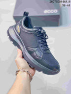 Three-quarter side view of the ECCO sneaker showing the dark mesh-and-overlay upper, heel branding, and rugged outsole.