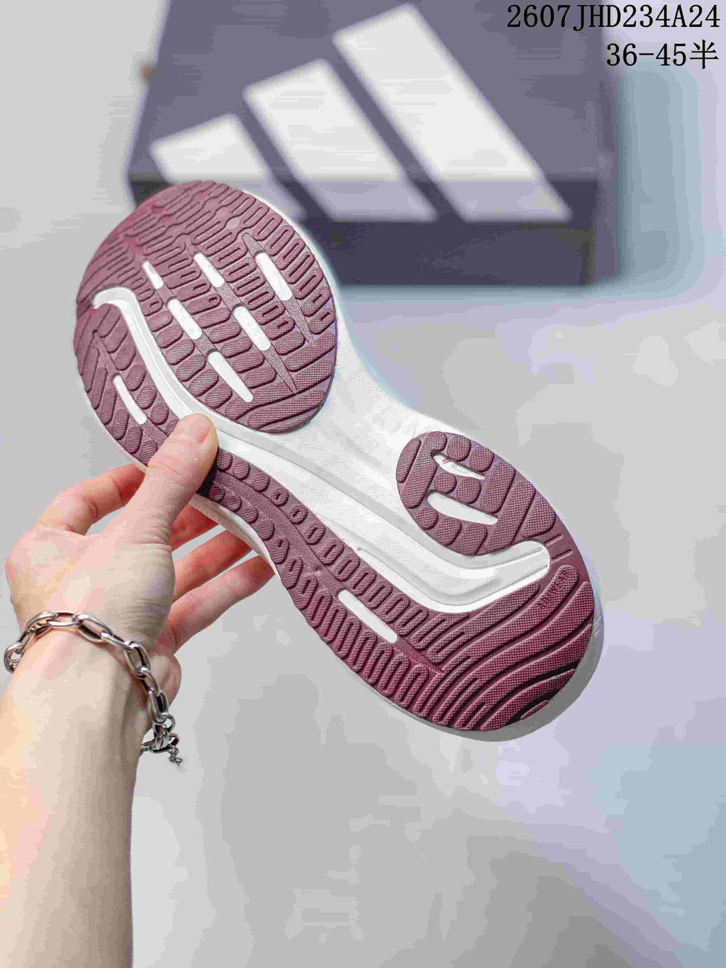 Underside view showing the burgundy-toned outsole tread and white midsole detailing.