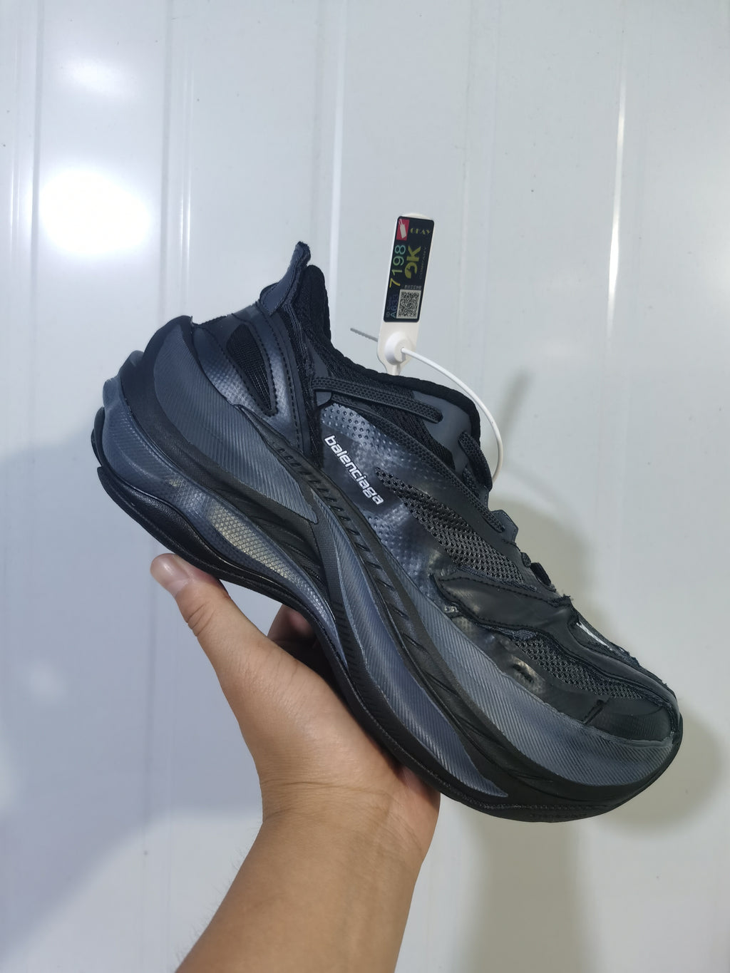 Angled view of the black Balenciaga sneaker showing the branded upper, lace fastening and layered outsole.