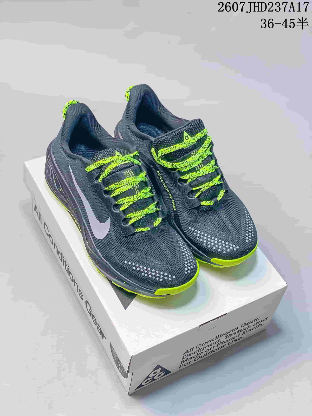 Pair of dark gray and neon lime Nike ACG trail shoes displayed on a shoe box.