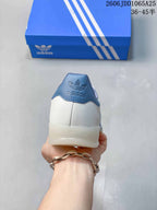 Rear view showing the white heel, blue padded collar, adidas logo, and translucent outsole.
