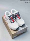 Pair of white On Cloudrunner 3 sneakers with red accents and black patterned laces displayed on a shoe box.