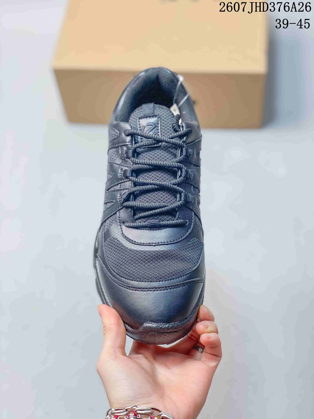 Top view of a black lace-up sneaker showing the mesh toe panel, stitched overlays and padded tongue.