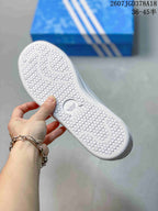 Close-up of the white textured outsole with circular tread details and Adidas branding.