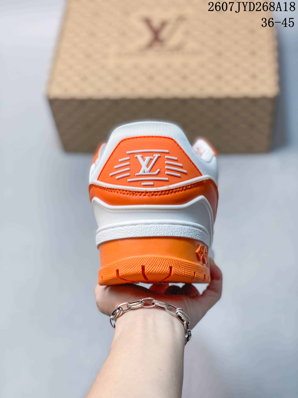 Rear view showing the white and orange heel structure and branded heel detail.