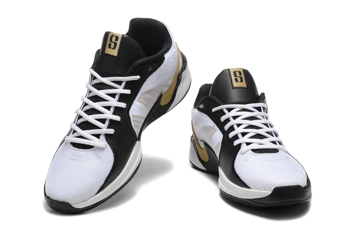 Pair of white, black, and gold low-cut basketball shoes shown from the front