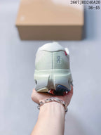 Rear view of a white sneaker showing the padded heel collar, On branding and segmented outsole.