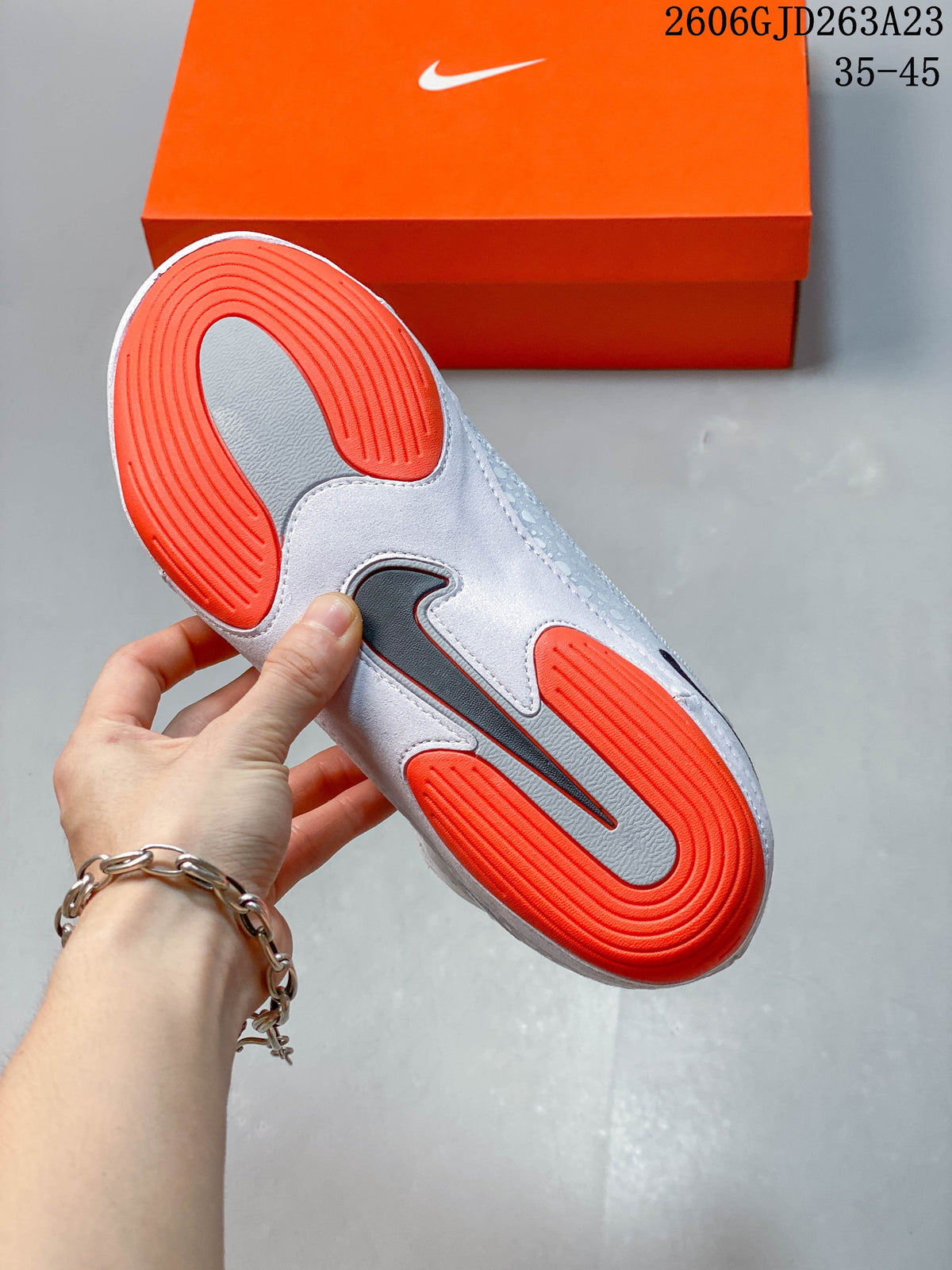 Underside of a wrestling shoe showing orange and grey outsole sections