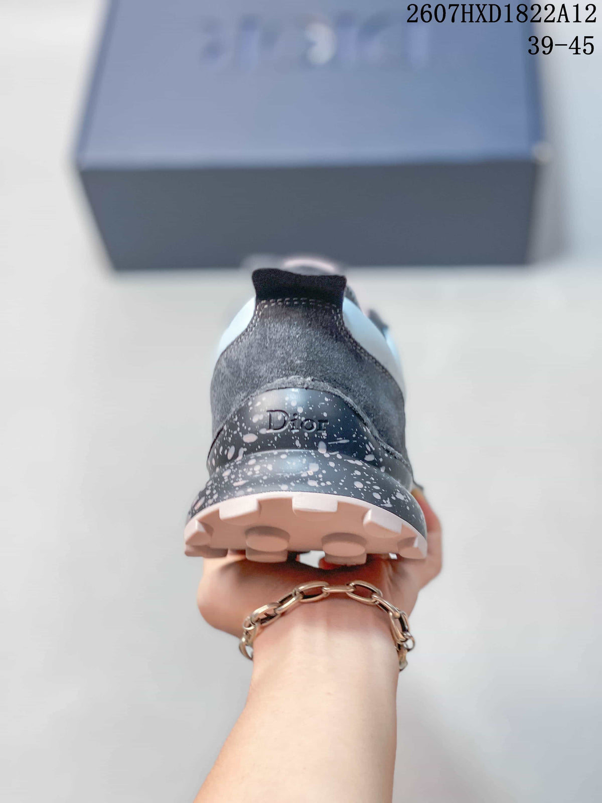 Rear view of a sneaker showing the Dior-marked heel, speckled midsole, and light pink outsole.