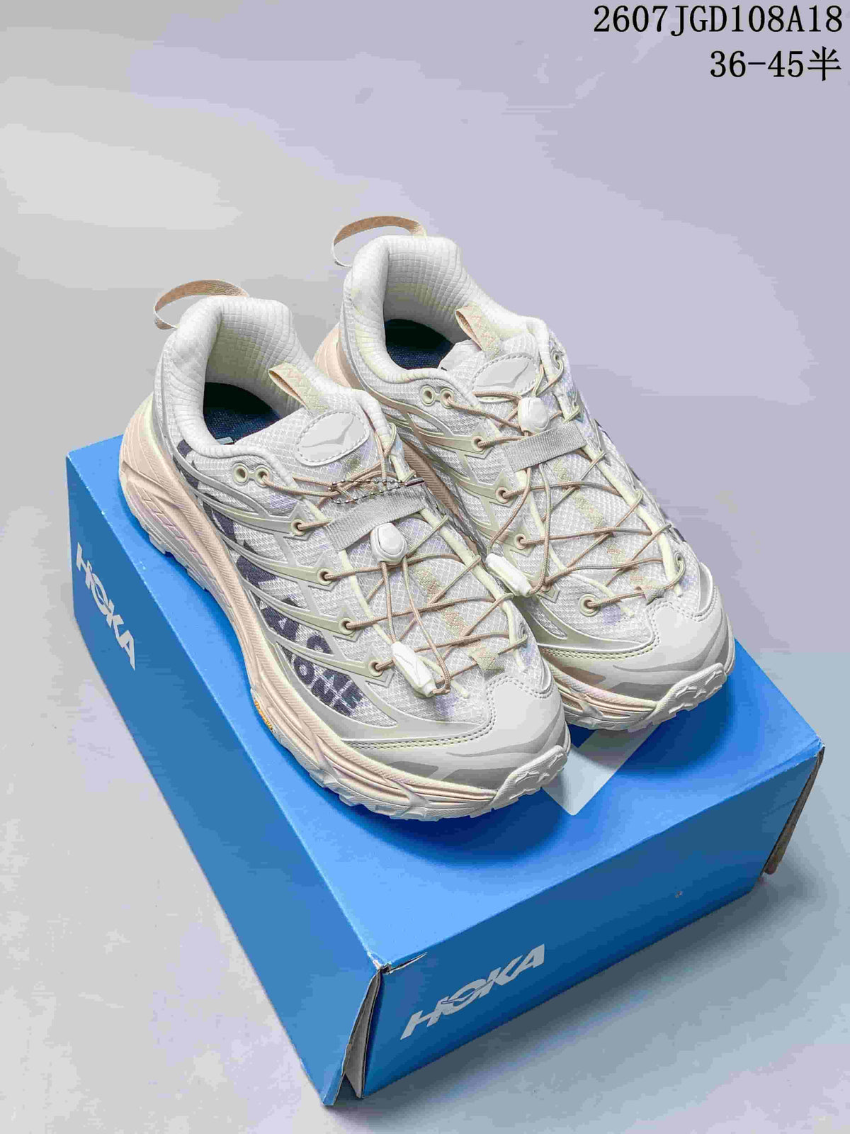 Pair of white and grey HOKA MAFATE SPEED 2 sneakers displayed on a blue shoe box; image text shows style code 2607JGD108A18 and size range 36–45 with half sizes.