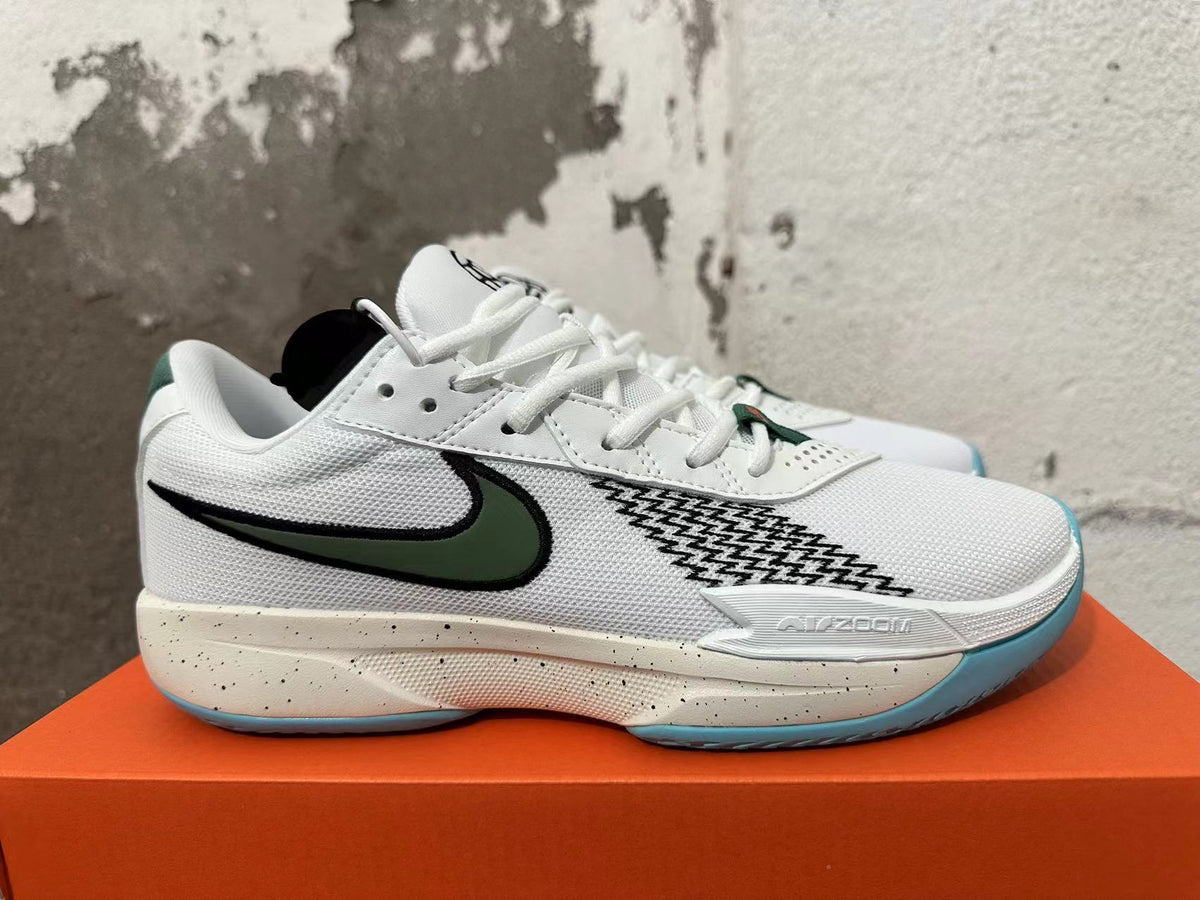 Side view of a white Nike basketball shoe with dark green and black detailing, a speckled midsole, and blue outsole