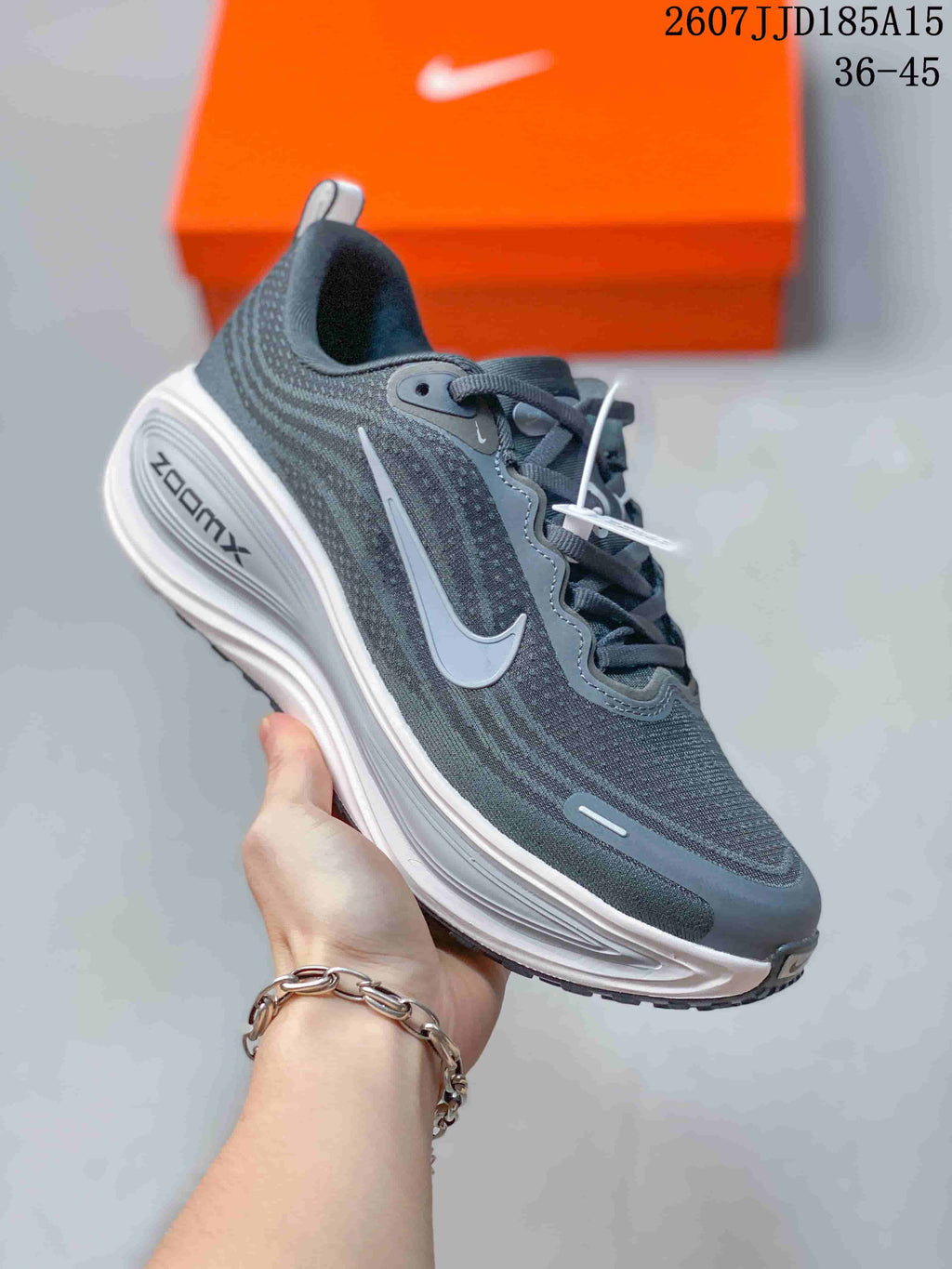 Close side view of a dark gray Nike Vomero Plus sneaker showing the layered sole and side swoosh.