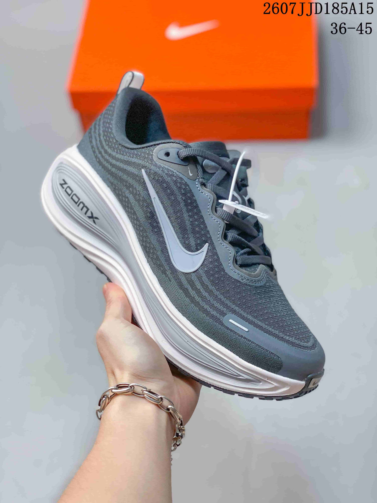 Close side view of a dark gray Nike Vomero Plus sneaker showing the layered sole and side swoosh.