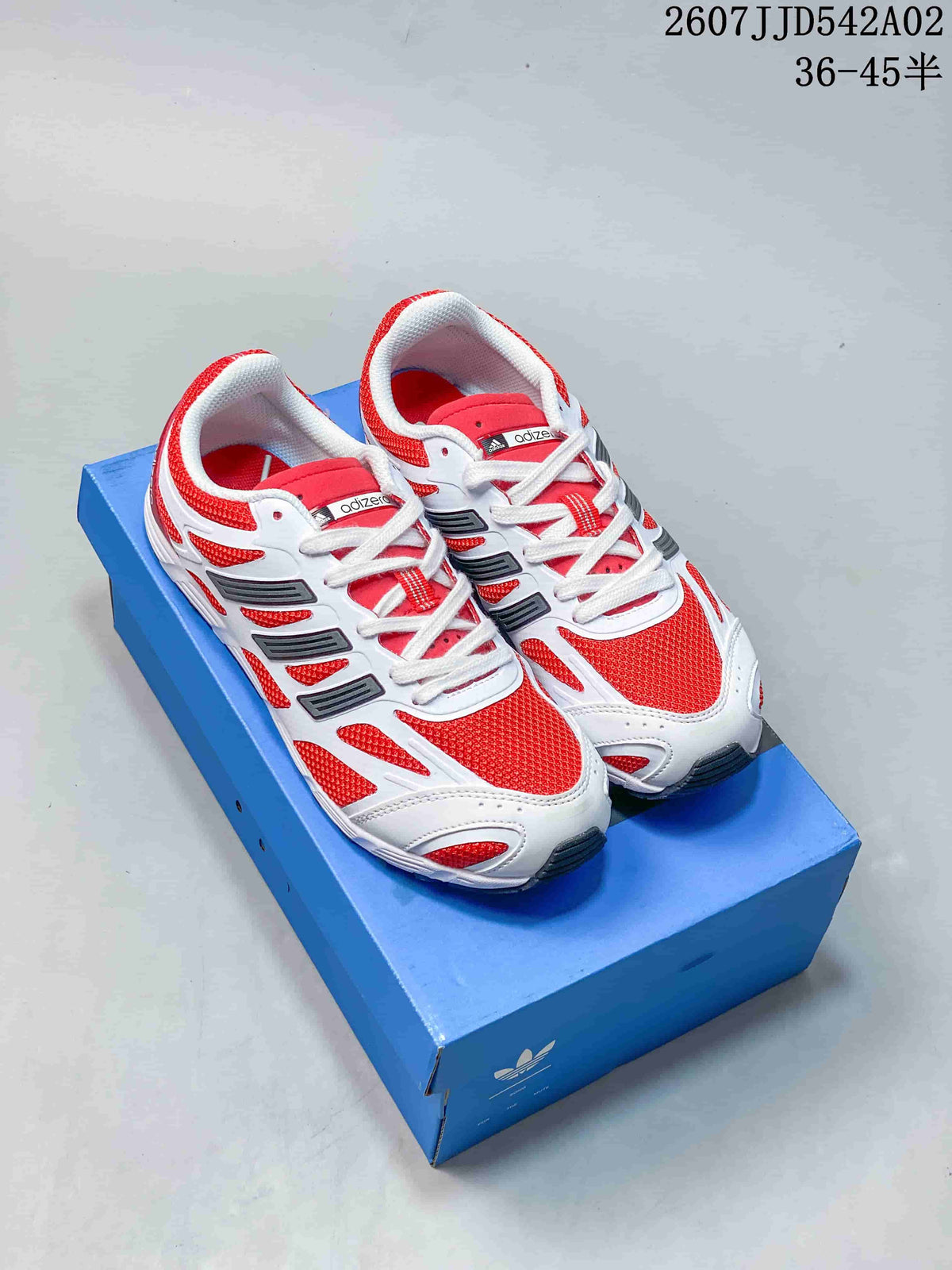 Red and white adidas Adizero PR SFTM sneakers shown on a blue box