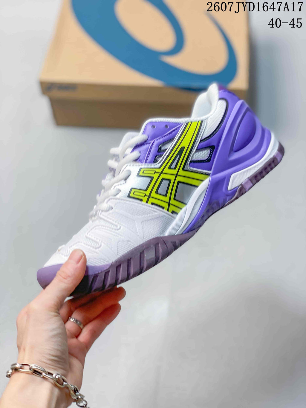 Side view of the white and purple tennis shoe with yellow ASICS side detailing and a textured outsole; image text shows style code 2607JYD1647A17 and size range 40–45.
