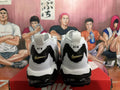 Rear view of white and black Nike-branded sneakers with gold-tone heel Swooshes and visible outsole cushioning.