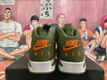 Rear view of olive green Jordan high-top sneakers with orange Nike Air branding and white midsoles