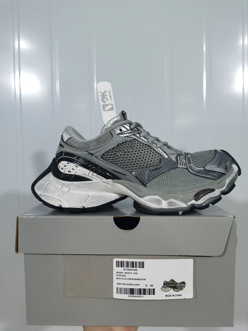 Pair of gray, silver and black sneakers displayed on a shoebox; the box label shows size E 40 and the color text “GREY/SILVER/BLK/W”.