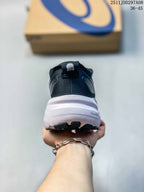 Rear view of a navy and white ASICS sneaker with a white midsole and visible PureGEL marking.