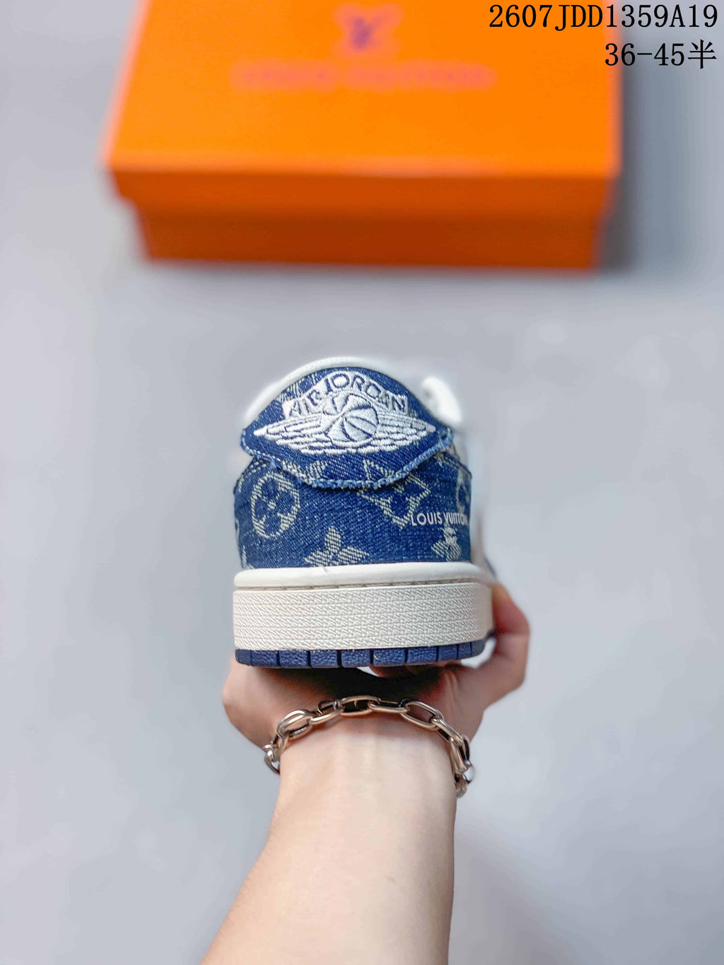 Rear view of the sneaker showing the blue patterned heel panel, white midsole, and blue outsole edge.