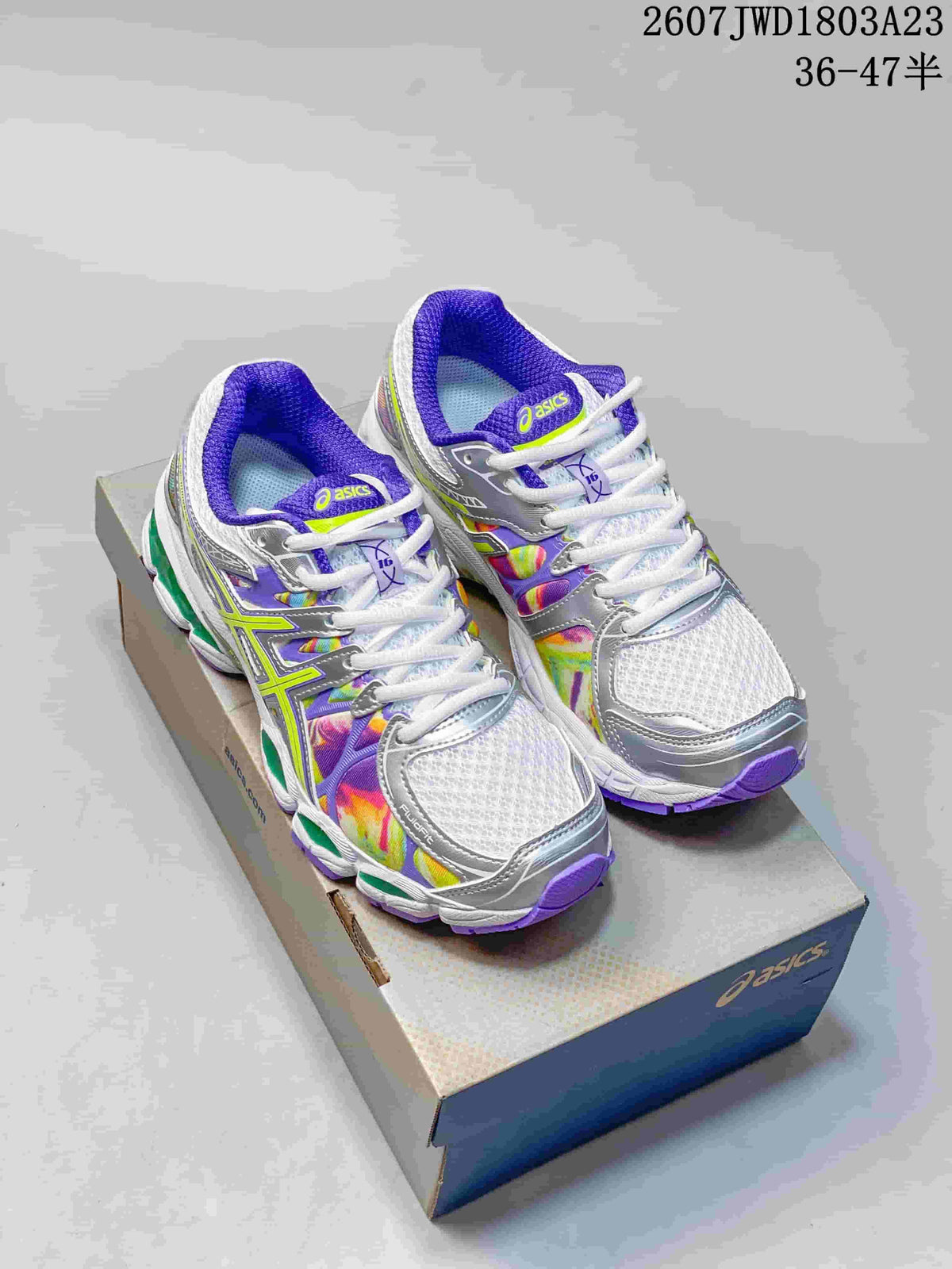 Pair of ASICS Gel-Nimbus 16 sneakers displayed on an ASICS shoebox, showing white, silver, purple, lime, and multicolor detailing.