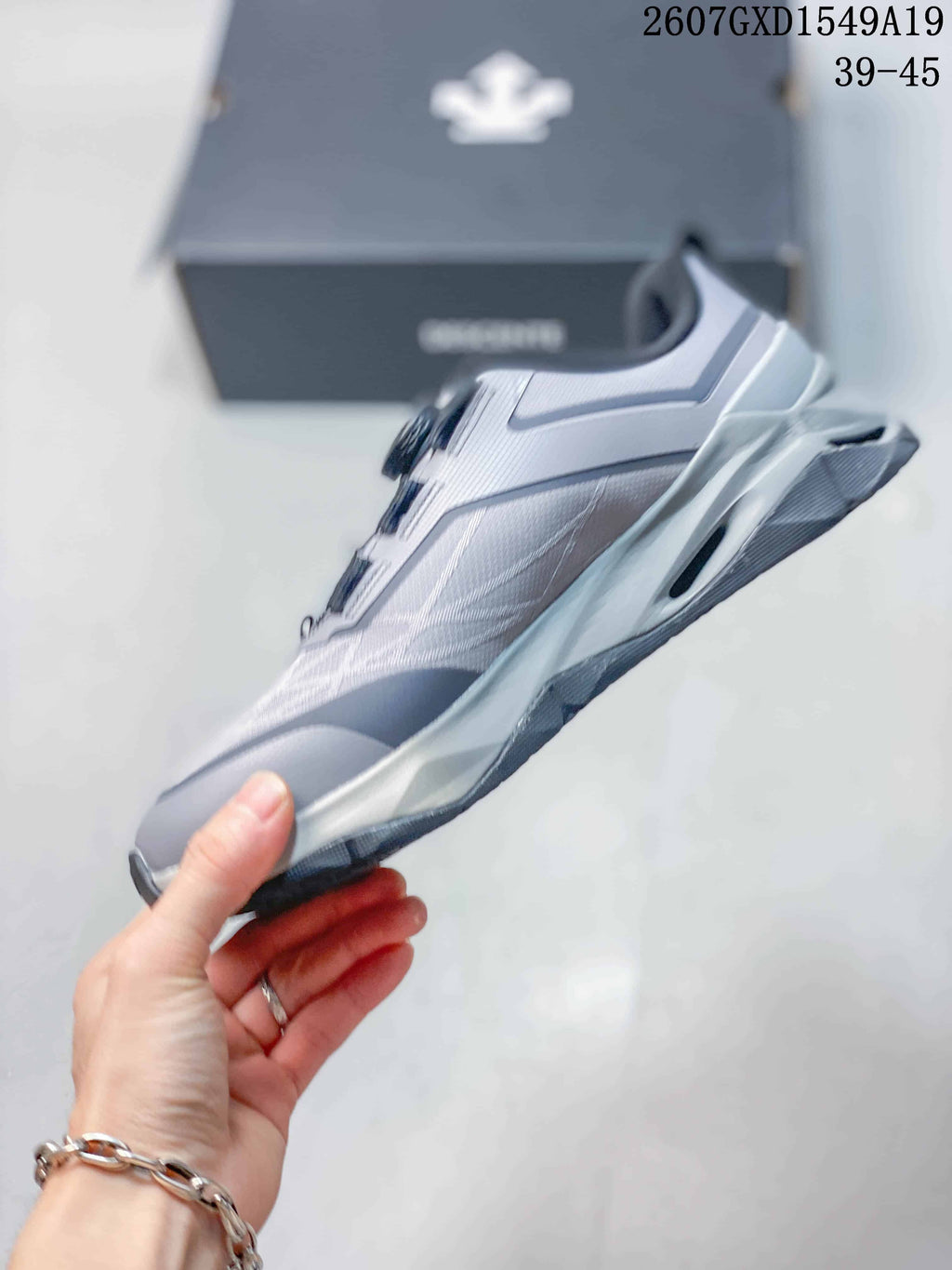 Side profile of the gray and white low-top training sneaker showing layered panels and the outsole structure.