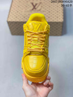 Top view of the yellow sneaker showing the rounded toe, laces, tongue and embossed monogram details.