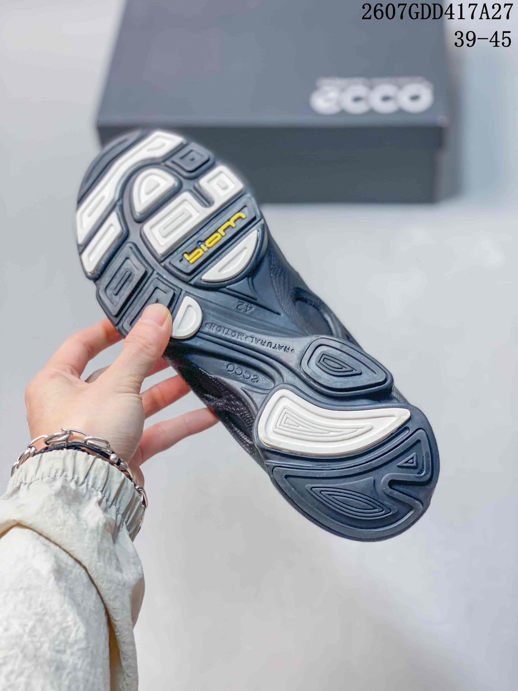 Close-up of the sneaker outsole showing a sculpted tread pattern with contrasting light sections and visible BIOM branding.