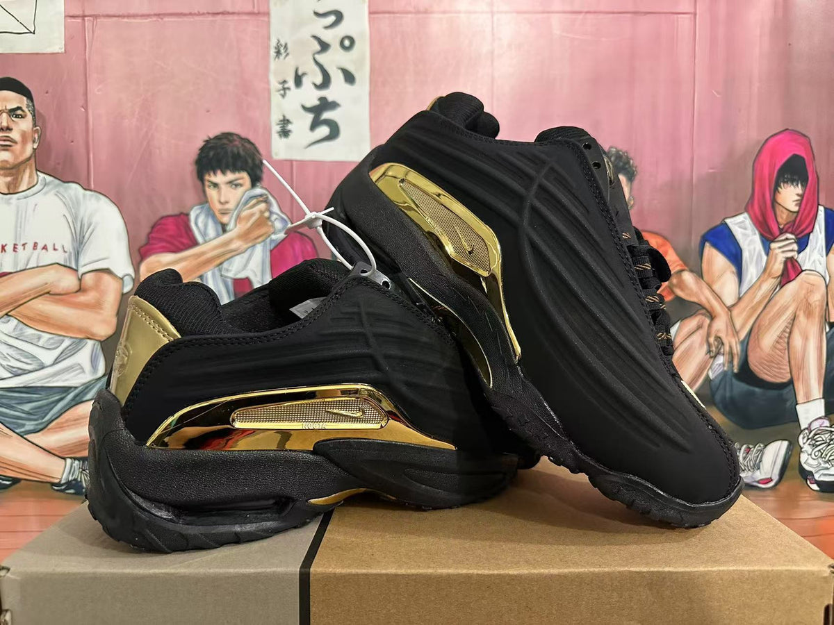 Angled view of the black shoes highlighting gold-tone side and heel accents.
