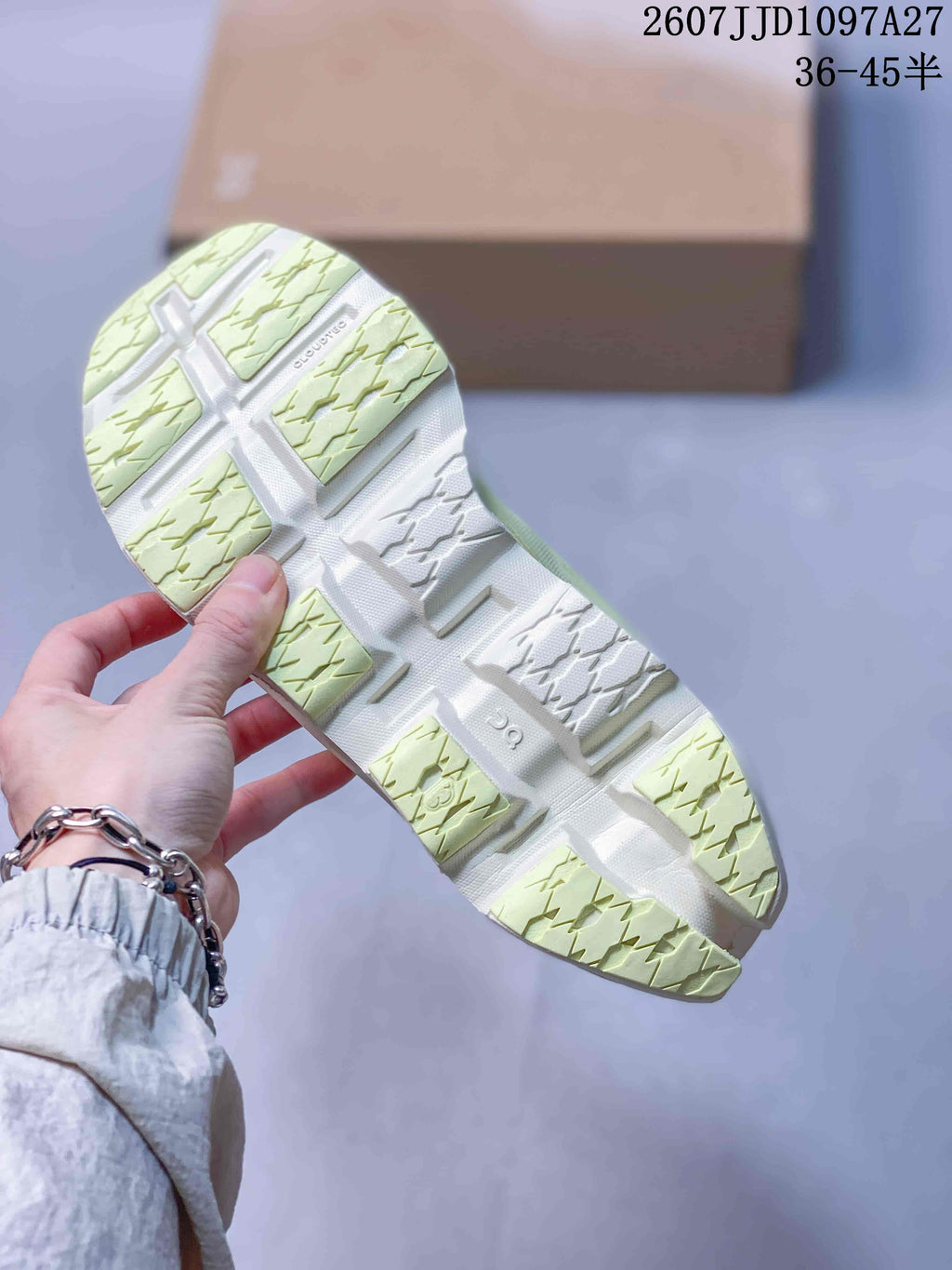 Underside view of the sneaker showing the segmented white and pale green outsole with textured tread.