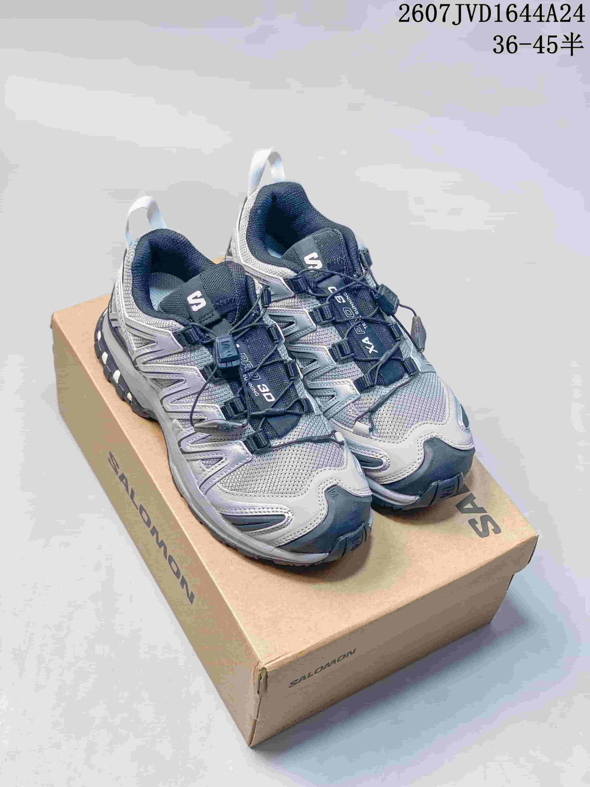 Pair of silver, gray, and dark navy Salomon XA Pro 3D Seasonal sneakers displayed on a Salomon shoebox.