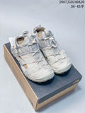 Pair of light gray and off-white The North Face sandals displayed on a shoe box, with multiple straps and mesh panels visible.