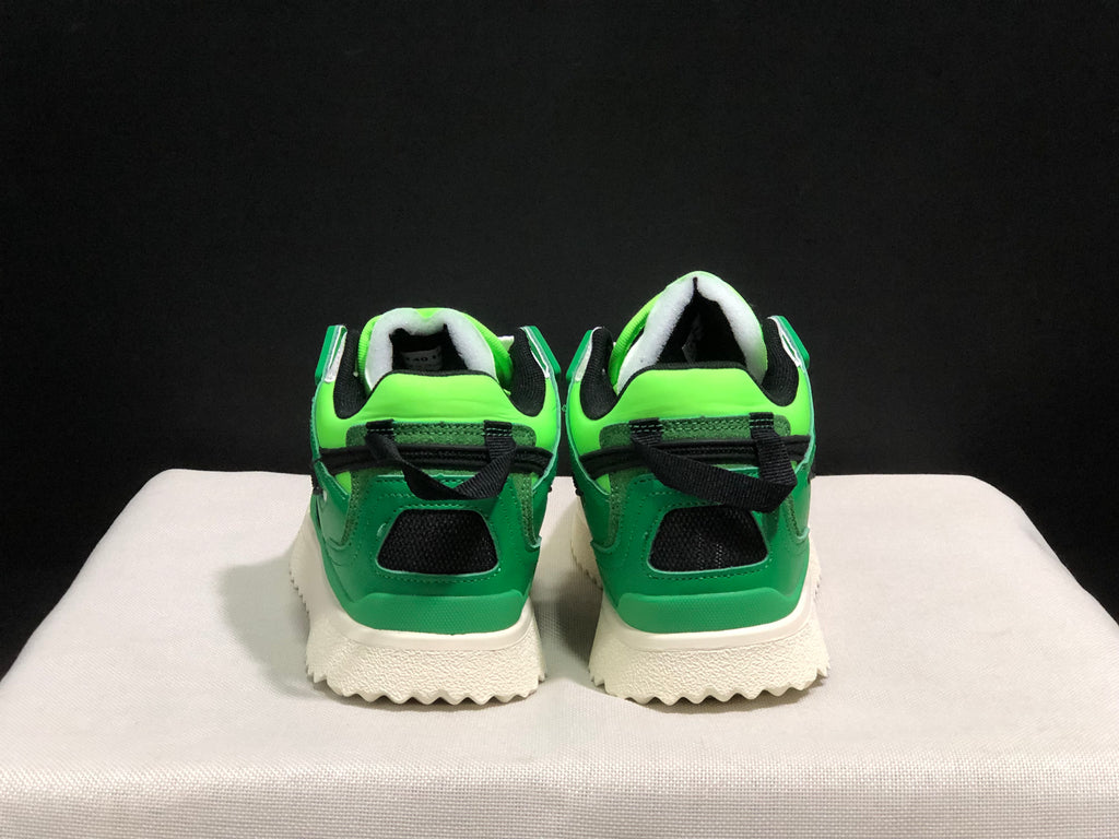Rear view showing the green heel panels, black heel accents, and textured cream outsole.