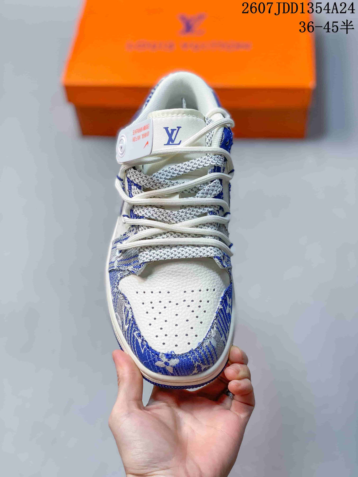 Front view of the blue and white Nike Dunk Low Retro sneaker showing the laces, perforated toe panel, patterned overlays, and tongue branding.
