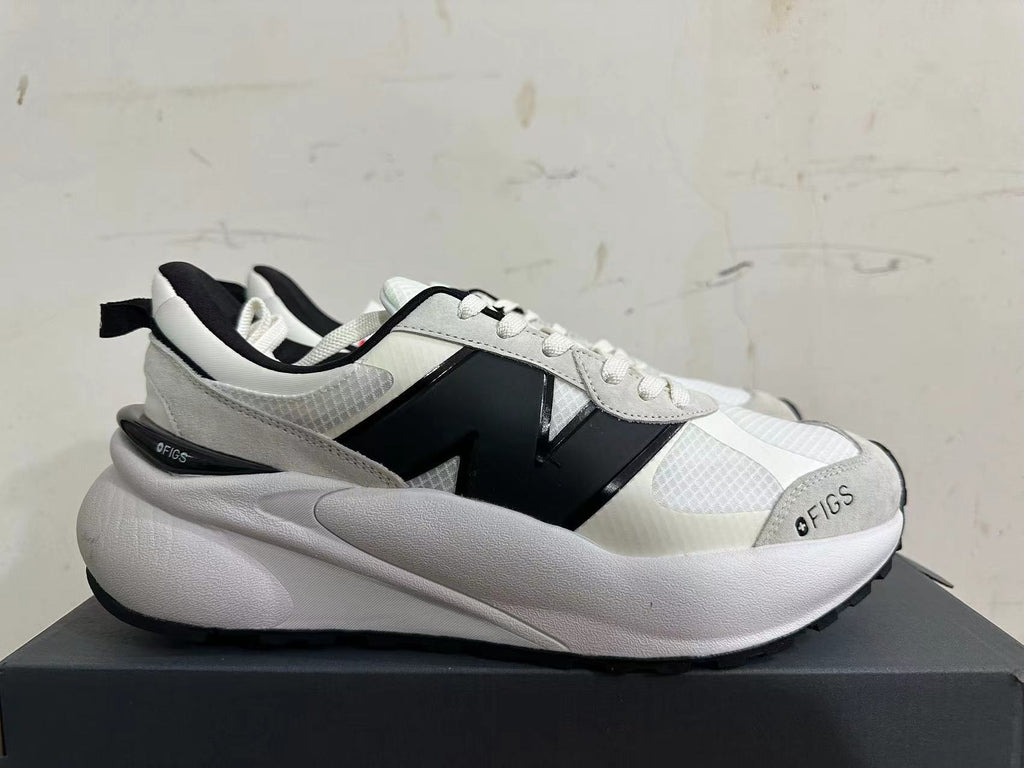 Side view of a white and light gray sneaker with a large black N-shaped detail and chunky sole