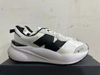 Side view of a white and light gray sneaker with a large black N-shaped detail and chunky sole