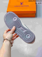 View of the gray patterned outsole and orange box