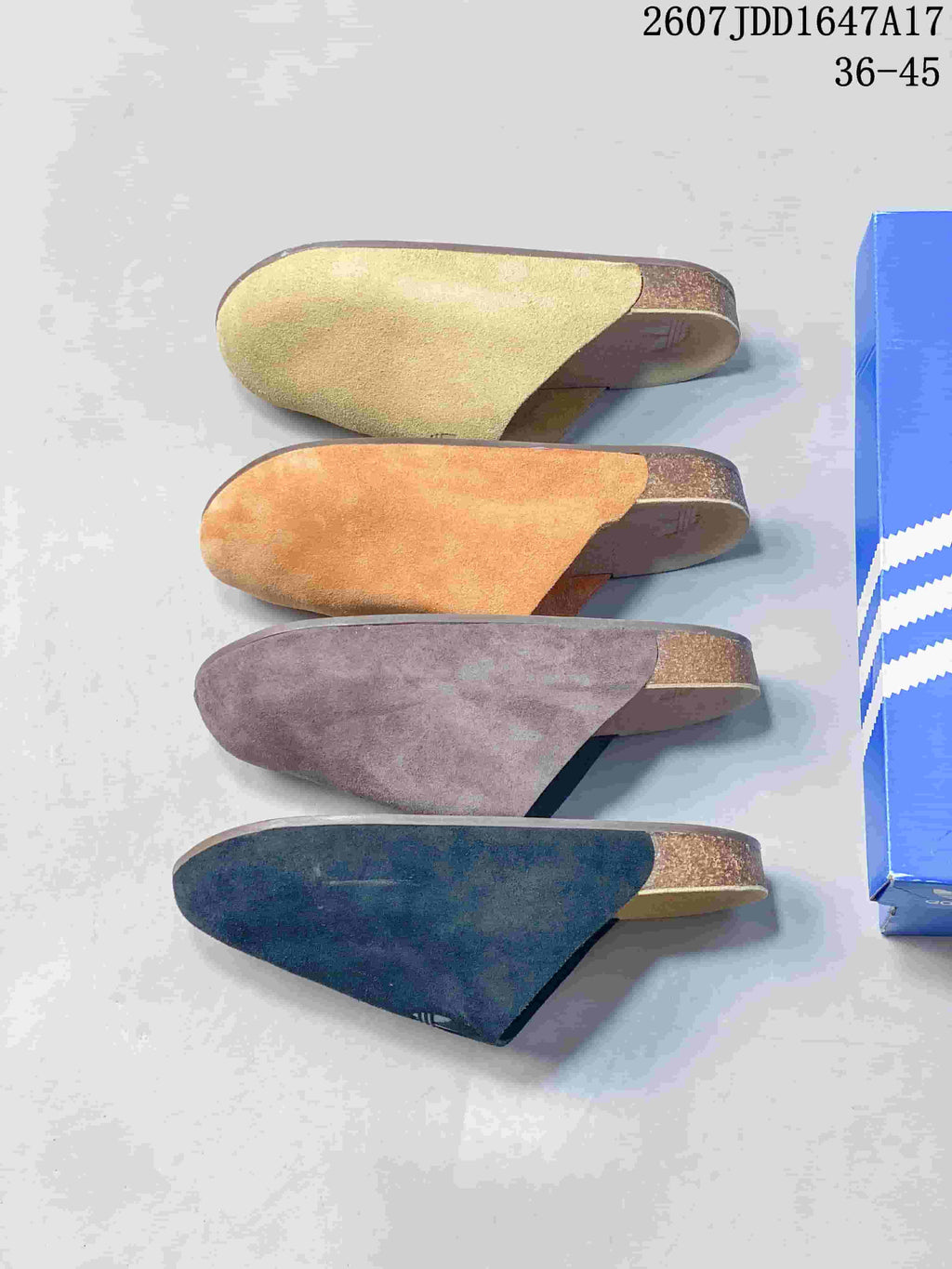 Four adidas Adimule mule slides arranged side by side in light green, orange, brown, and black colorways.