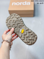 Close-up of the patterned sneaker outsole showing visible Vibram and Megagrip markings, with the branded box in the background.