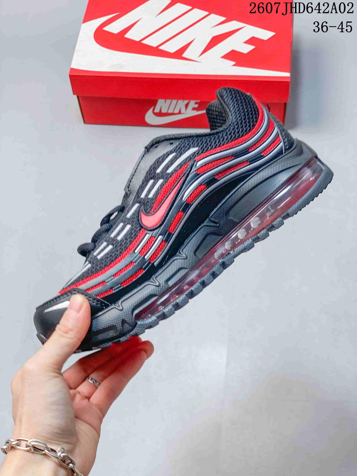Side view of a dark gray Nike Air Max TL 2.5 sneaker with red accents and a visible heel air unit.