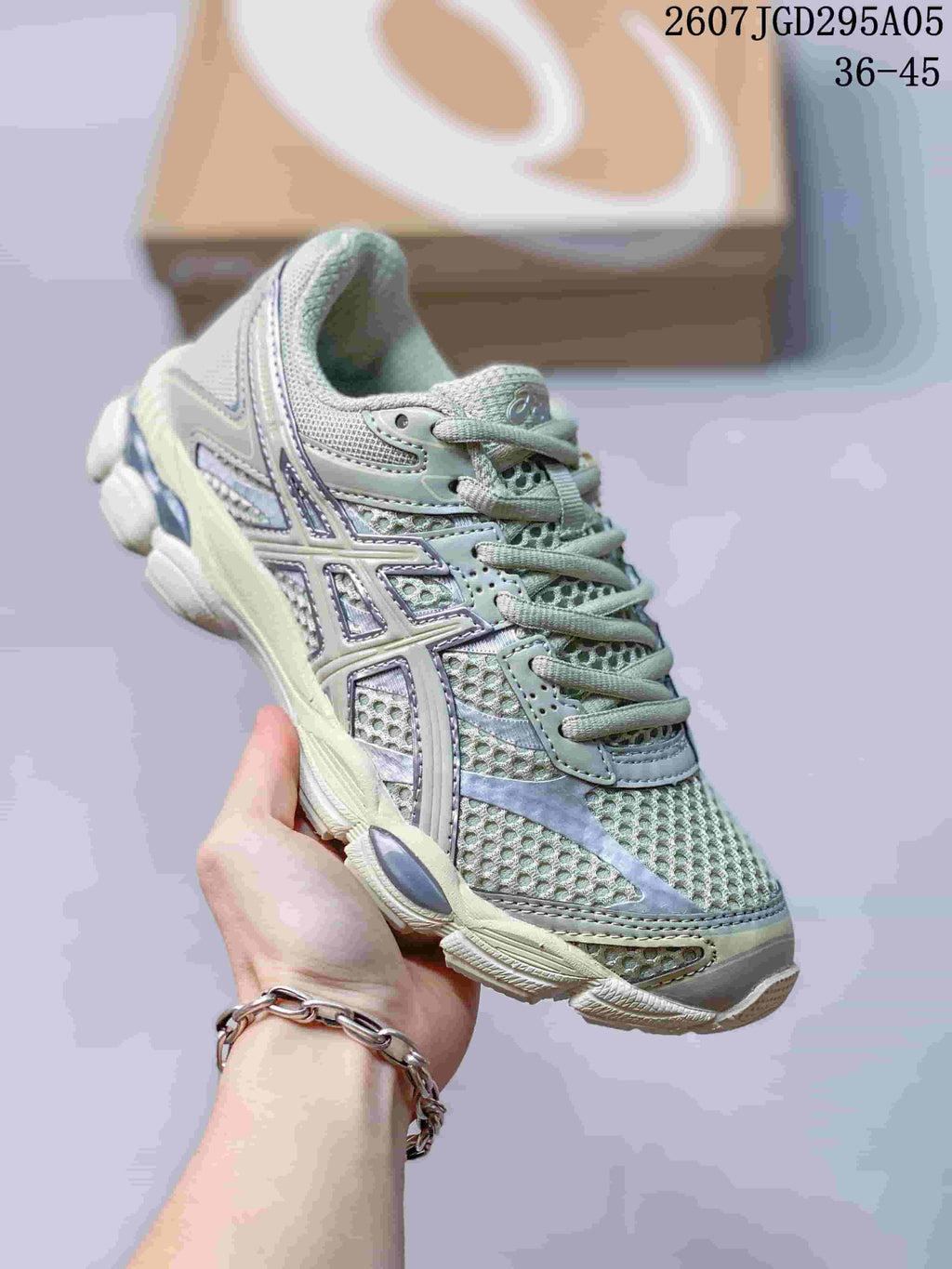 Three-quarter side view of the sneaker showing the layered upper, side branding, padded collar, and textured outsole; overlay text shows style code 2607TGD295A05 and size range 36–45.