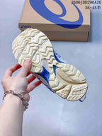 Close view of the sneaker outsoles showing a cream-colored tread pattern with angular lugs.