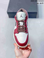 Top view showing the perforated white toe box, red overlays, brown laces, and tongue logo.