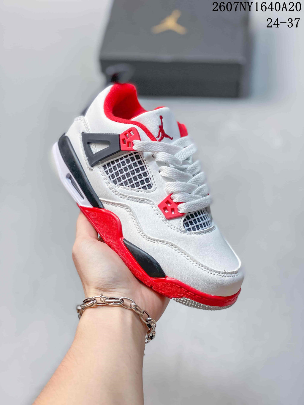 Angled side-front view showing the white upper, mesh panels, red outsole, and black structural accents.