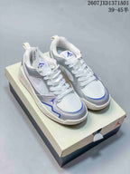 Pair of white and silver Jordan CMFT Era low-top sneakers with blue accents, displayed on a shoebox.